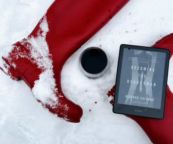 My red rubber boots, a glass of red wine, my Kindle, featuring Becoming the Boogeyman, by Richard Chizmar. All of these things are in the snow.