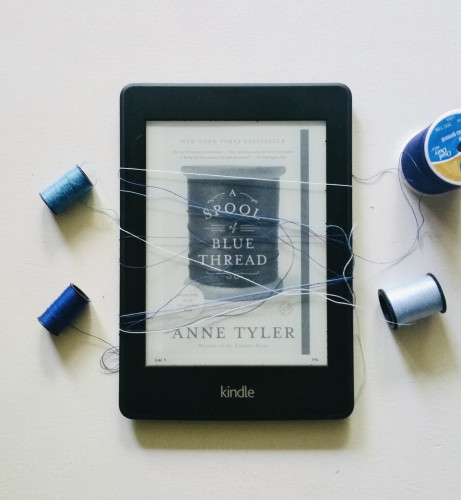 My Kindle, featuring, A Spool of Blue Thread by Anne Tyler and is surrounded by four spools of blue thread. 