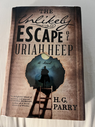 Image shows a page with a tear in the middle with a dark figure in Victorian men’s clothes walking away. Text says “The Unlikely Escape of Uriah Heep H. G. Parry.” Cover blurb says “‘A delightful blend of mystery and marvel.’—Louisa Morgan, author of A Secret History of Witches”
