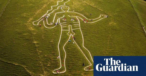 Large chalk outline of nude man holdind a club in a green landscape.