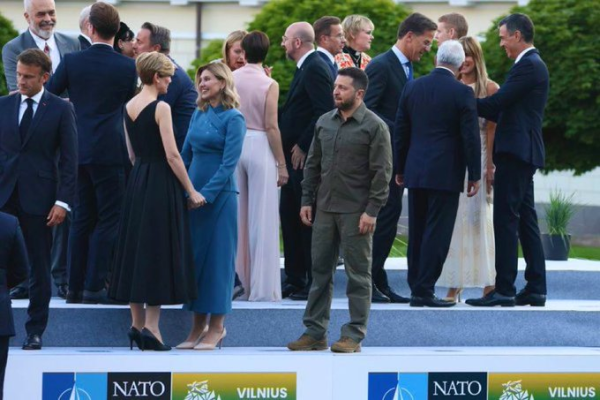 This is a meme depicting Volodymyr Zelenskyy attending a NATO event where everyone appears comfortable except for Zelenskyy. The meme humorously portrays the experience of a solitary #linux #sysadmin at upper management meetings.