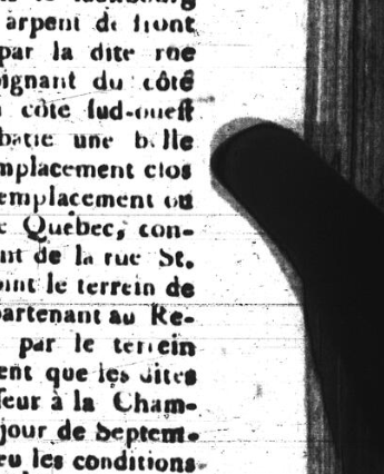 A section of microfilmed late-eighteenth-century French-language newsprint held in place for the camera by a ghostly thumb.