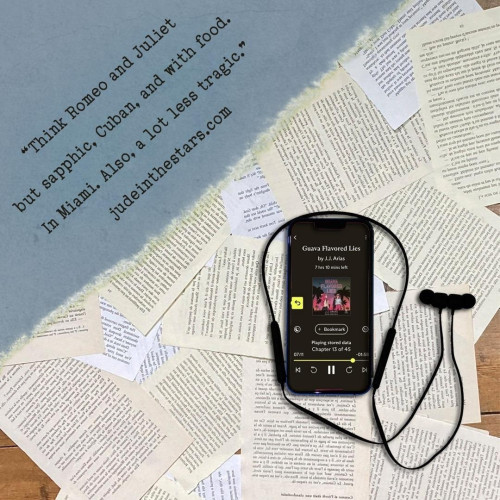 On a backdrop of book pages, an iPhone with the cover of Guava Flavored Lies by J.J. Arias, narrated by Carrie Coello. In the top left corner of the image, a strip of torn paper with a quote: "Think Romeo and Juliet but sapphic, Cuban, and with food. In Miami. Also, a lot less tragic." and a URL: judeinthestars.com.