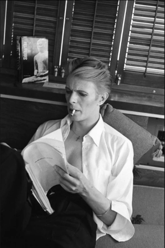 Pictured is David Bowie from the Thin White Duke days. He's enjoying a read and a smoke. 