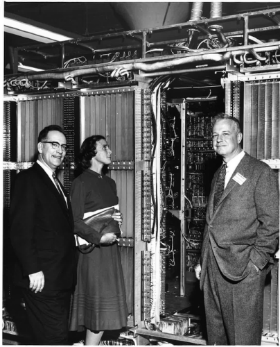 Black & white image of two men and a woman looking at interior of the UNIVAC LARC computer.