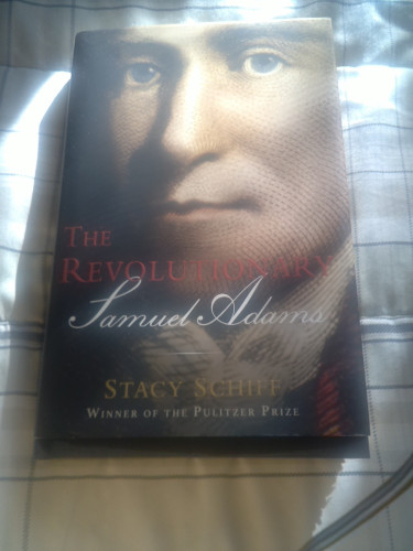 A book cover with the title of The Revolutionary Samuel Adams,  the name of the author Stacy Schiff, and a picture of Adams.